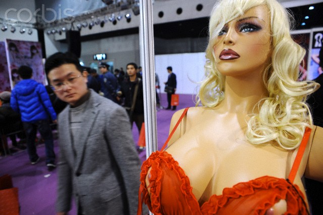 11 Mar 2011, Shanghai, China --- A visitor looks at an inflatable sex doll during the China Adult-Care Expo 2011 in Shanghai, China, 11 March 2011. China is the worlds largest manufacturer of sex toys, over 70% of the worlds marital aids are produced in China, according to surveys. China has over 1,000 sex toy manufacturers, a statistic researched and released by the China Market Research center. In the past few years, annual production output for sex toys in China has reached over US$2 billion. --- Image by © Imaginechina/Corbis